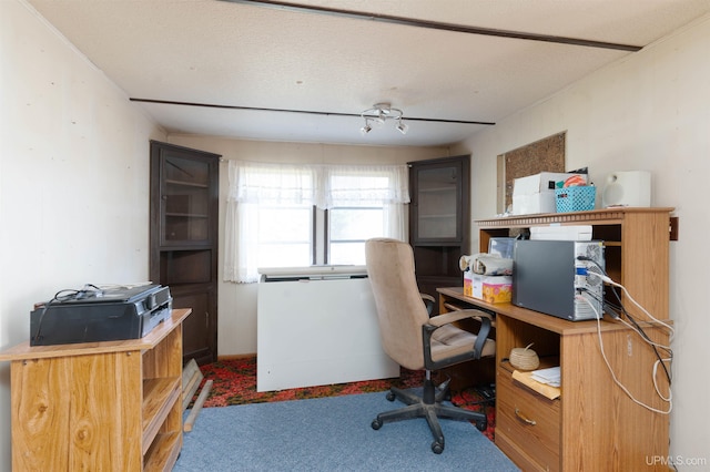 carpeted home office featuring a textured ceiling