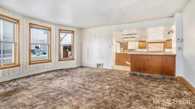 unfurnished living room with crown molding and carpet