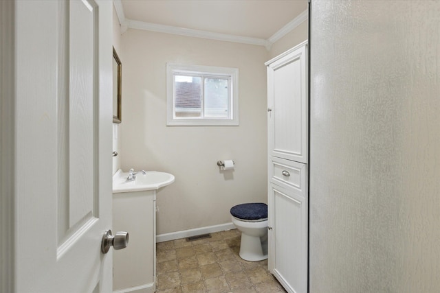 bathroom with toilet, vanity, and ornamental molding