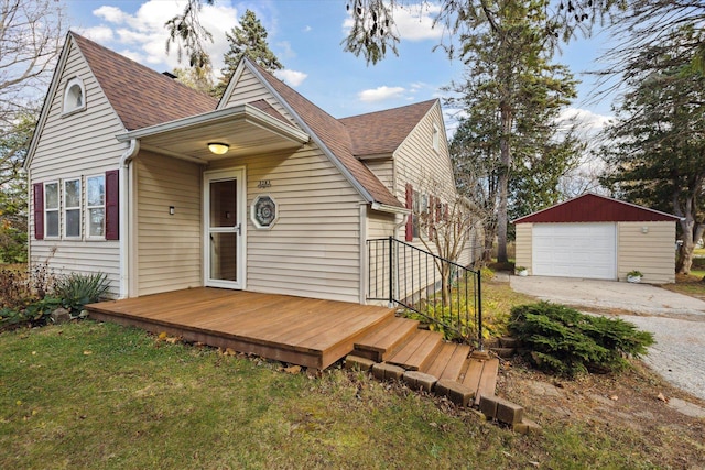 view of front of home featuring a garage, a front lawn, and an outdoor structure