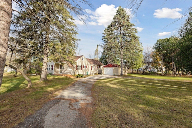 view of front of house with an outbuilding, a garage, and a front lawn