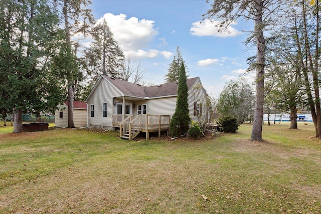 rear view of house with a lawn and a deck