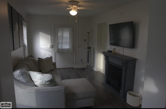 living room featuring dark wood-type flooring and ceiling fan