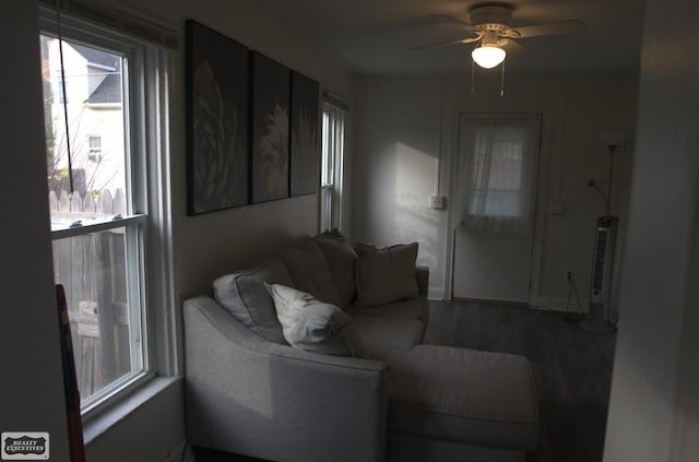 living room with dark hardwood / wood-style flooring and ceiling fan