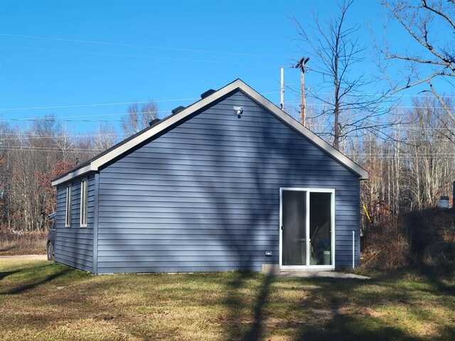 view of side of home with a yard