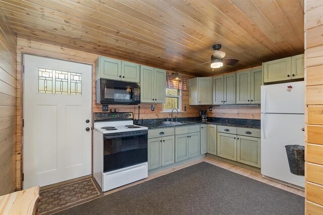 kitchen with wood walls, sink, white appliances, ceiling fan, and light wood-type flooring