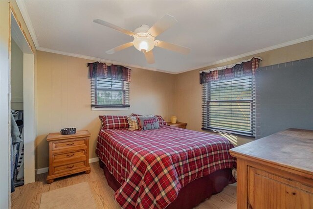 bedroom featuring ceiling fan, crown molding, and light hardwood / wood-style floors