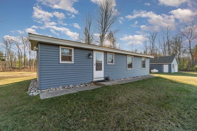 view of front of house with a front yard and an outbuilding