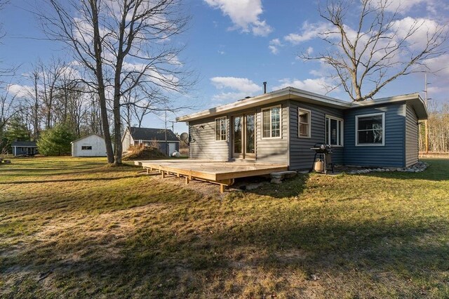 back of house with a lawn and a wooden deck