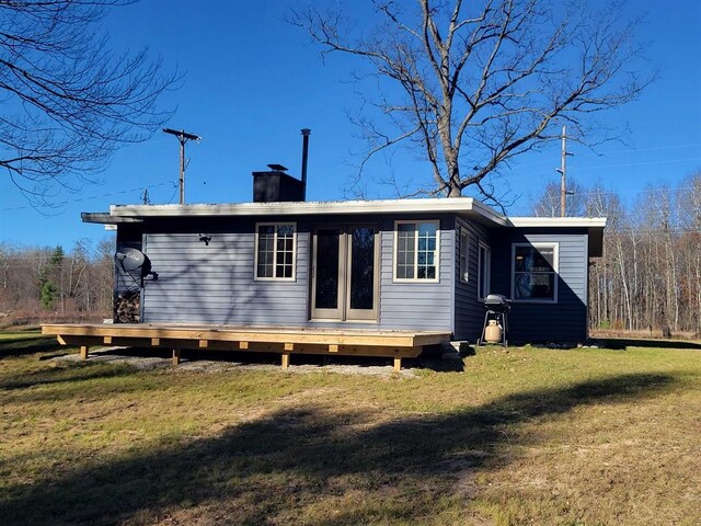 back of house with a wooden deck and a yard