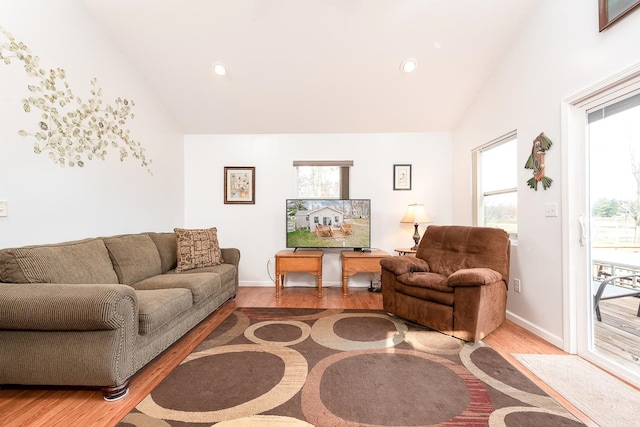 living room featuring vaulted ceiling and wood-type flooring