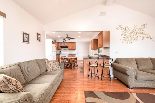 living room with beamed ceiling, high vaulted ceiling, light hardwood / wood-style flooring, and ceiling fan