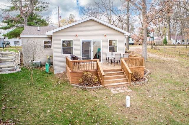 rear view of property featuring a yard and a deck