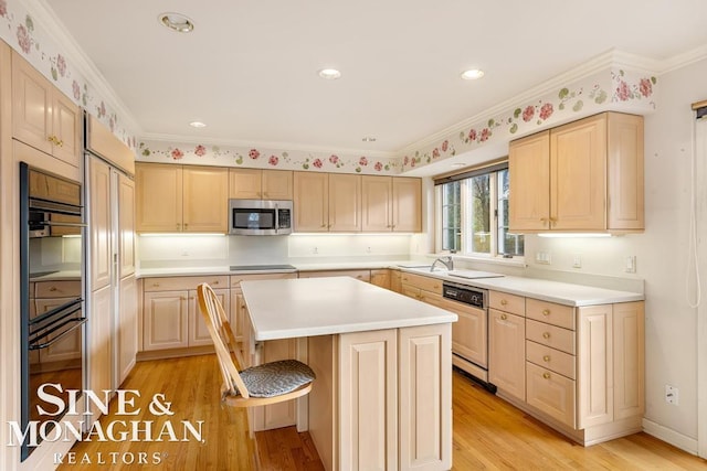 kitchen with a kitchen island, black appliances, light wood-type flooring, and ornamental molding