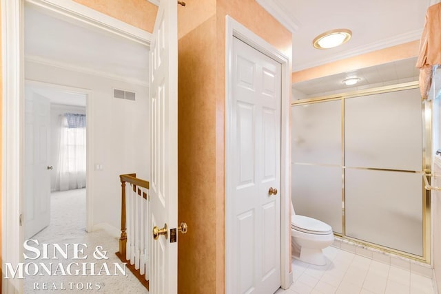 bathroom with tile patterned floors, ornamental molding, an enclosed shower, and toilet