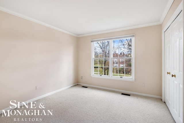 unfurnished bedroom with a closet, crown molding, and light carpet