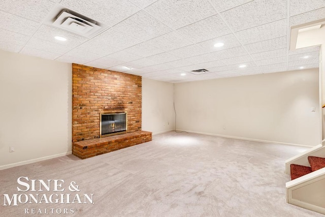 unfurnished living room with a fireplace, a drop ceiling, and carpet floors