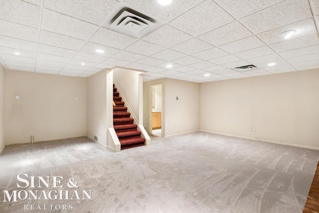 basement featuring carpet and a paneled ceiling