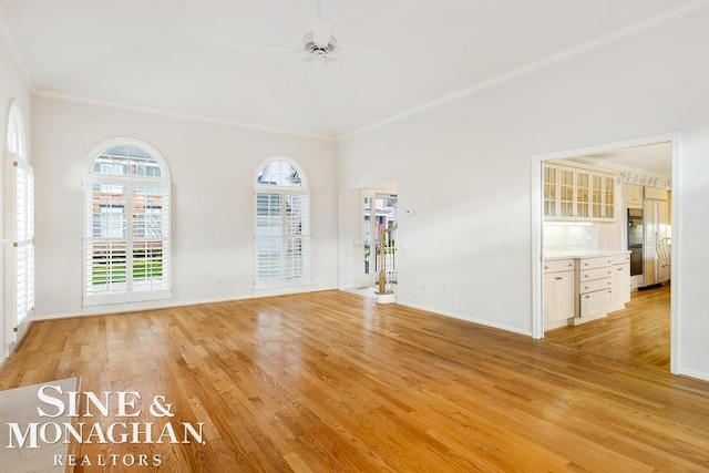 unfurnished room with crown molding, plenty of natural light, and light hardwood / wood-style flooring