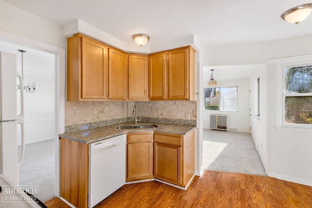 kitchen with sink, tasteful backsplash, white appliances, stone countertops, and light wood-type flooring