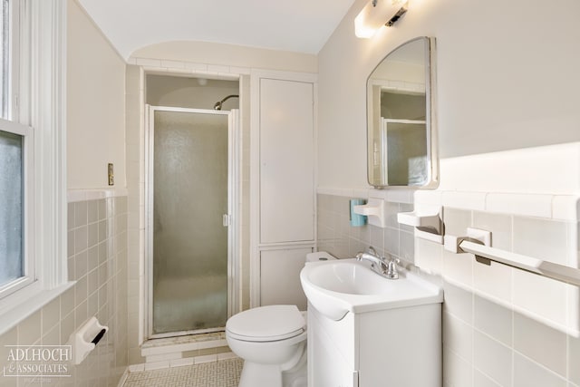 bathroom featuring vanity, a shower with shower door, tile walls, and tile patterned flooring