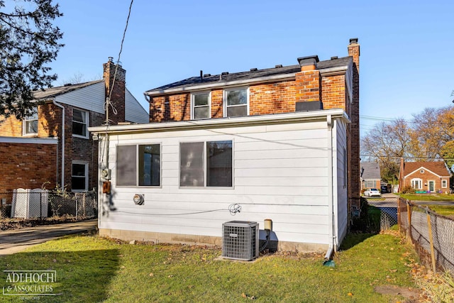 back of house featuring central AC and a yard