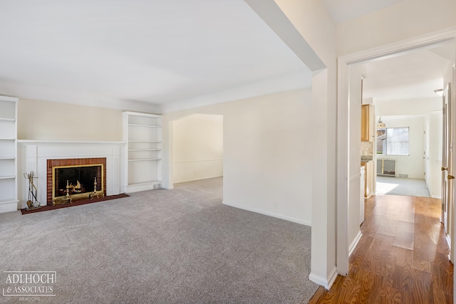 unfurnished living room with hardwood / wood-style floors and a brick fireplace