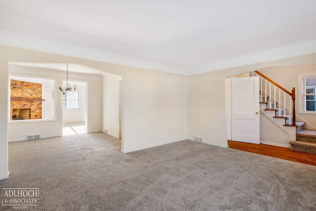 empty room with carpet flooring and a chandelier