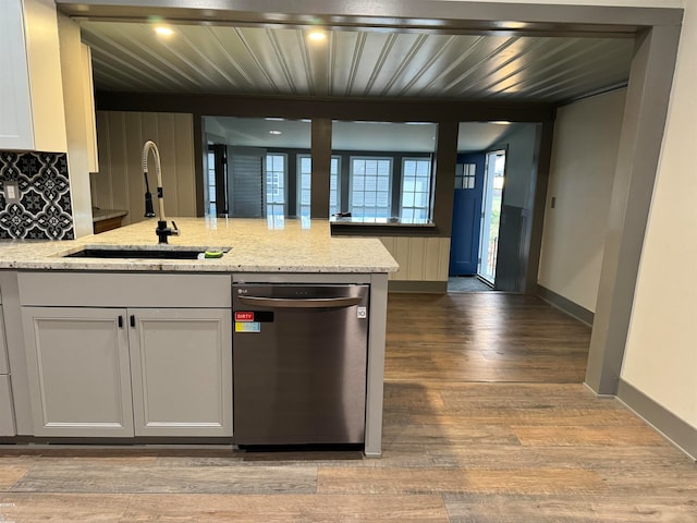 kitchen featuring sink, stainless steel dishwasher, light stone countertops, light wood-type flooring, and white cabinetry