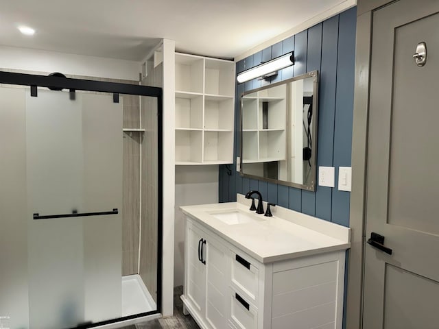 bathroom with wood-type flooring, vanity, and a shower with door