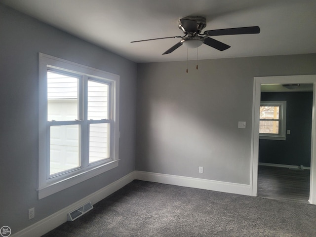 unfurnished room featuring dark carpet and ceiling fan