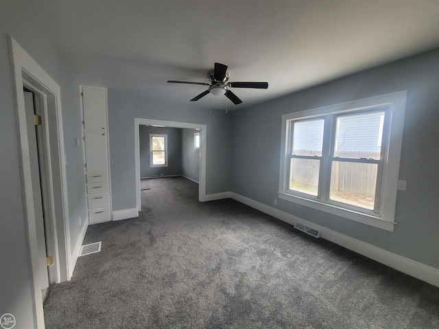 unfurnished bedroom featuring dark carpet and ceiling fan