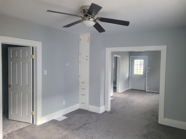 empty room with ceiling fan and carpet