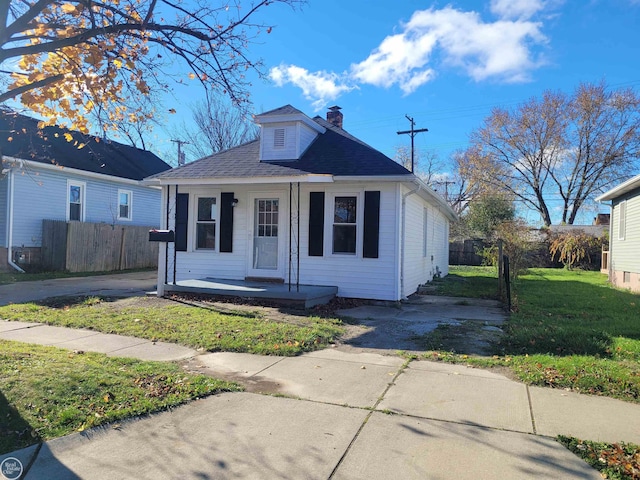 bungalow with a porch and a front lawn