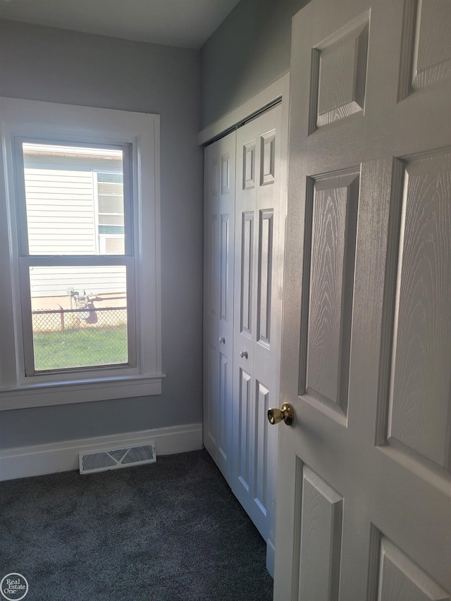 doorway to outside featuring dark colored carpet