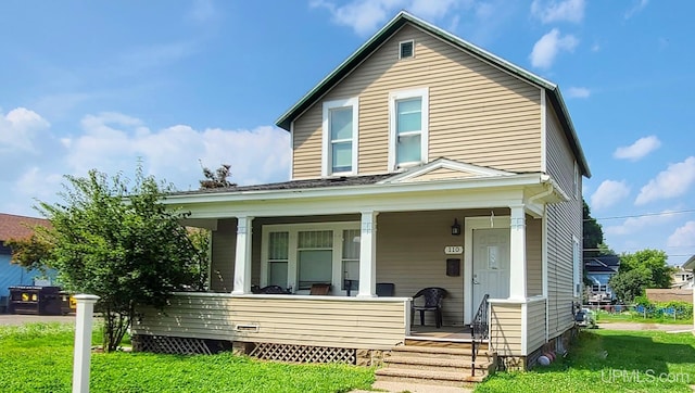 view of front of property with a porch and a front lawn