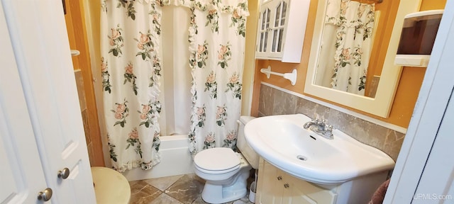 full bathroom featuring sink, tasteful backsplash, toilet, and shower / tub combo with curtain