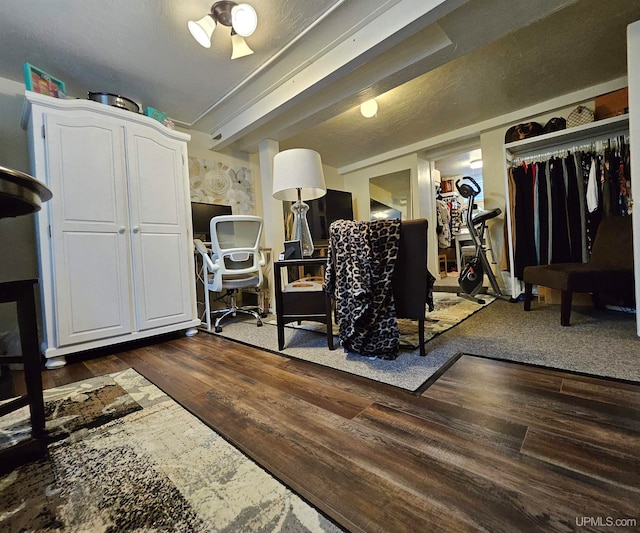 workout room featuring dark hardwood / wood-style floors and a textured ceiling