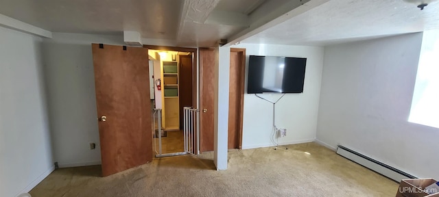 unfurnished bedroom with light colored carpet and a baseboard heating unit