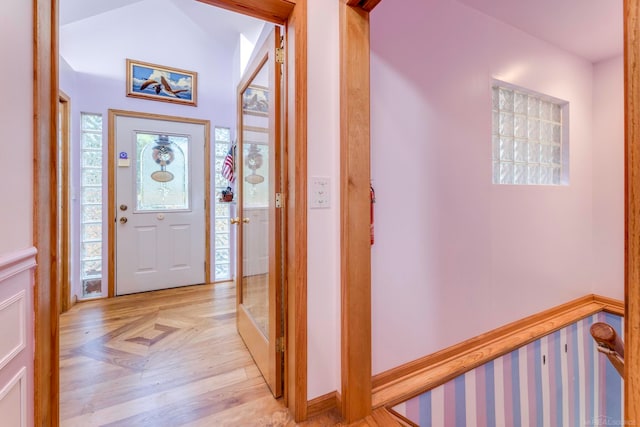 entryway featuring light parquet floors and vaulted ceiling