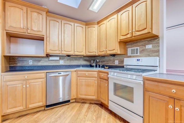 kitchen with tasteful backsplash, gas range gas stove, sink, light hardwood / wood-style flooring, and dishwasher