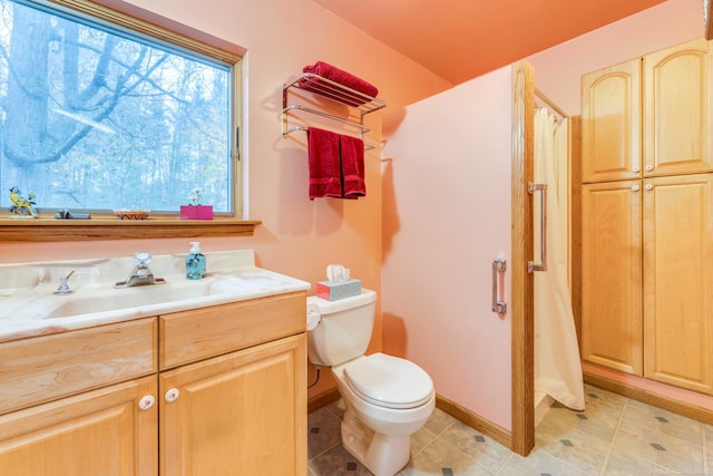 bathroom with tile patterned flooring, vanity, toilet, and walk in shower