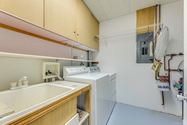 laundry room featuring electric panel, sink, cabinets, and washing machine and dryer