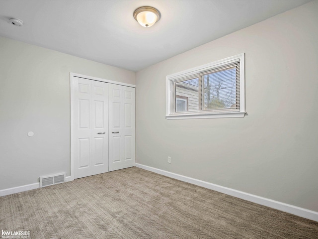 unfurnished bedroom featuring carpet flooring and a closet