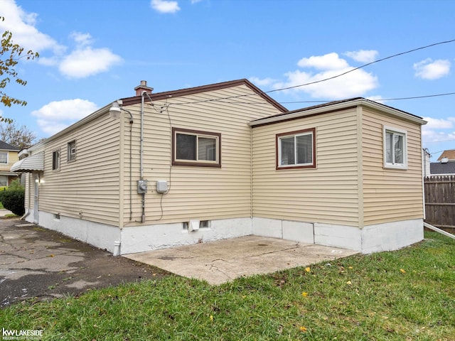 back of property with a yard and a patio