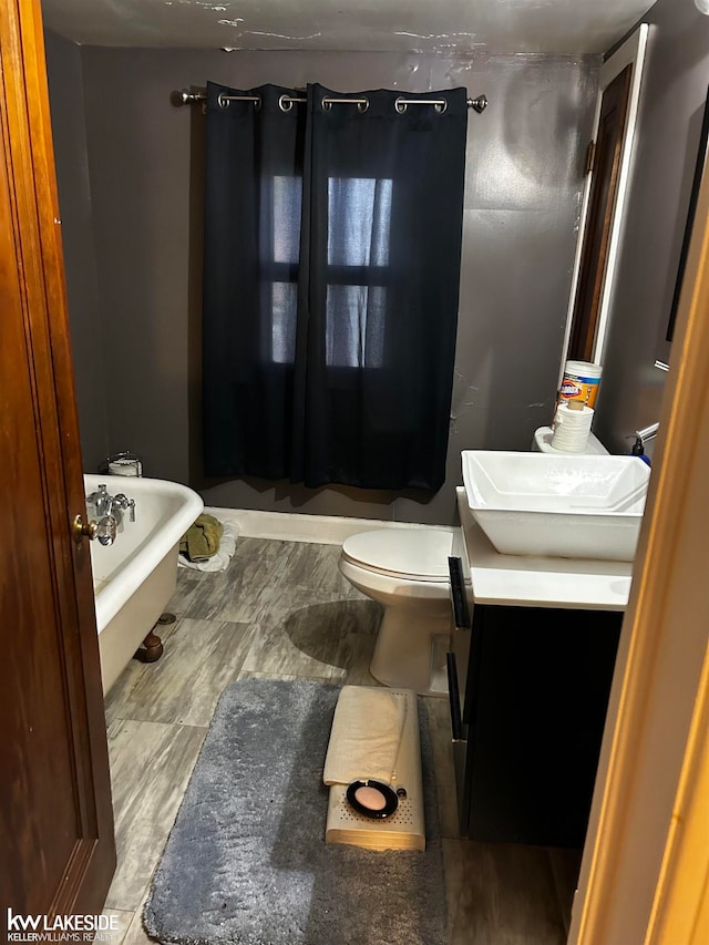 bathroom with vanity, toilet, and a tub