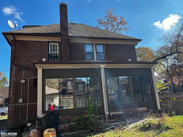 rear view of property featuring a sunroom