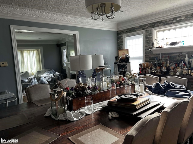 dining area with ornamental molding, wood-type flooring, a chandelier, and a textured ceiling