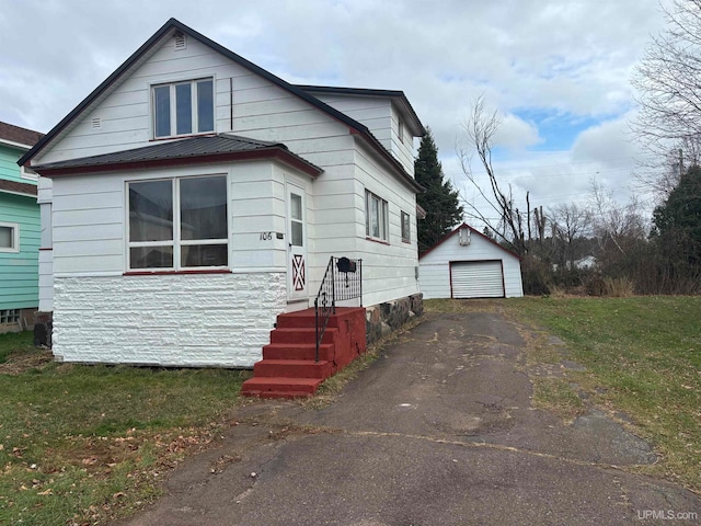 bungalow-style house with a garage and an outbuilding