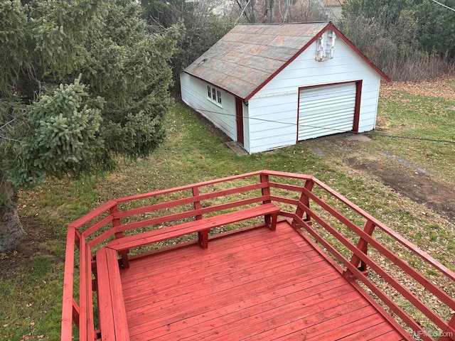 wooden deck with a garage, an outbuilding, and a yard